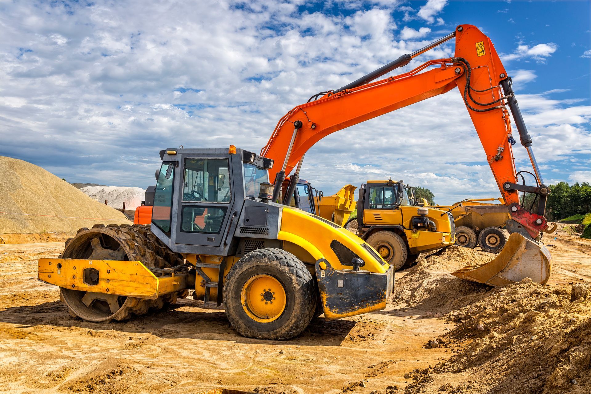 A group of construction vehicles are working on a construction site.
