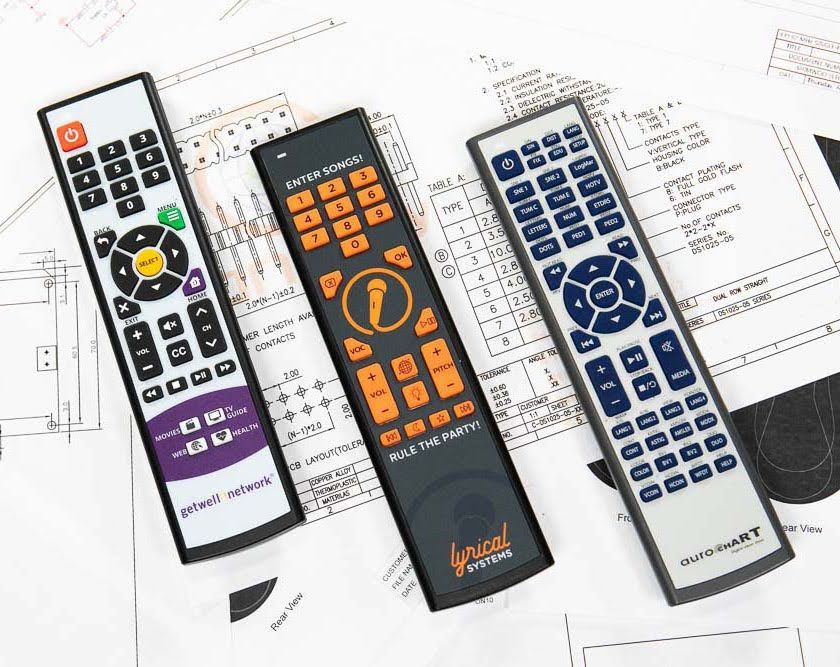 Three colorful remote controls on a blueprint.