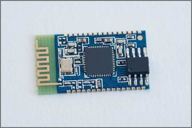 Blue and green Bluetooth module with various electronic components.