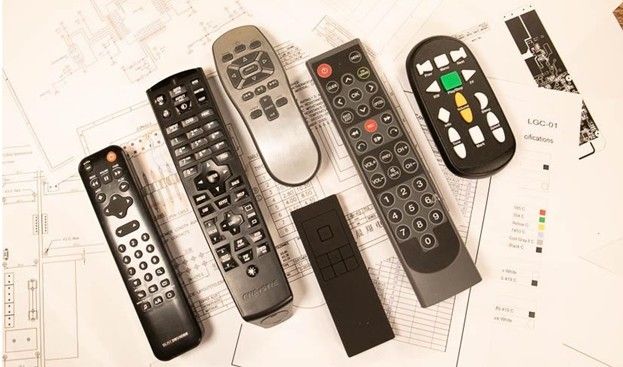 Assorted TV remote controls in black and silver on a white background