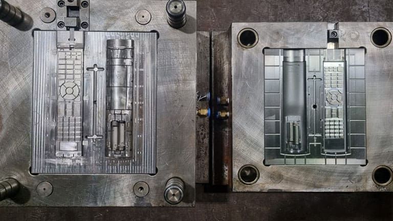 Metal mold halves, one on each side, for making a remote control.