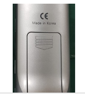 Silver remote control with battery compartment. Marked 