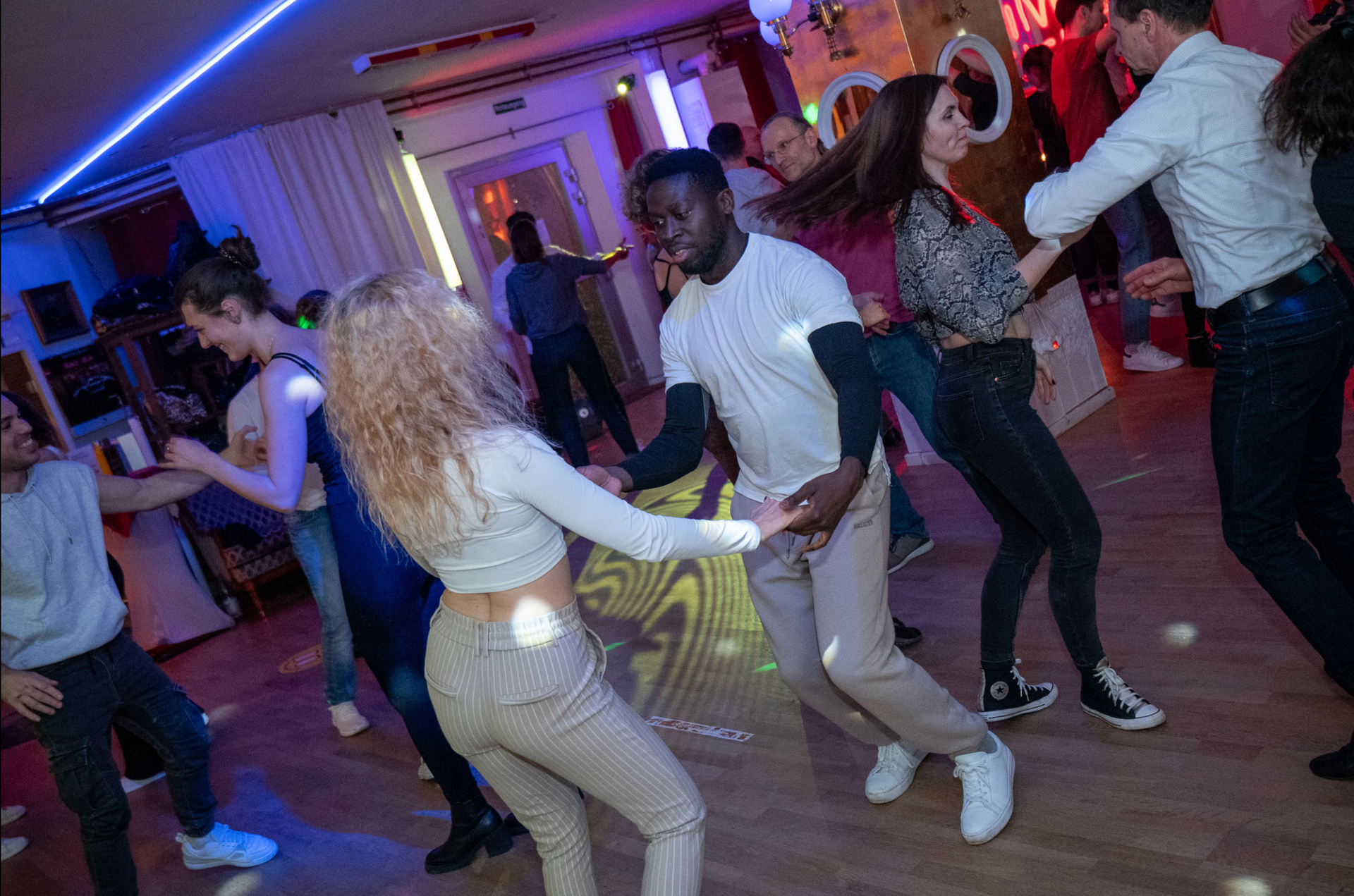 A group of people are dancing on a dance floor at a party.