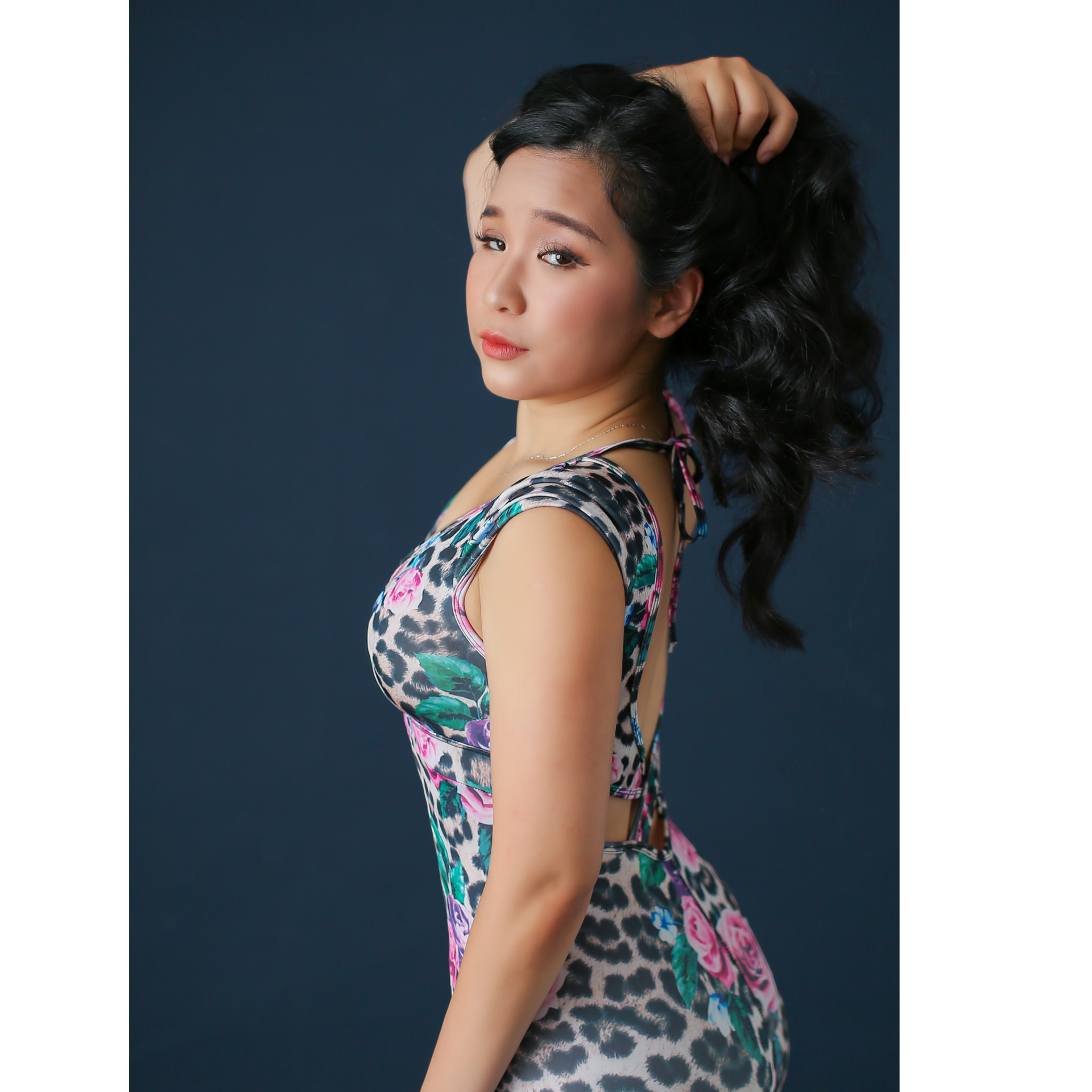 A woman in a white top and jeans is standing on one leg.