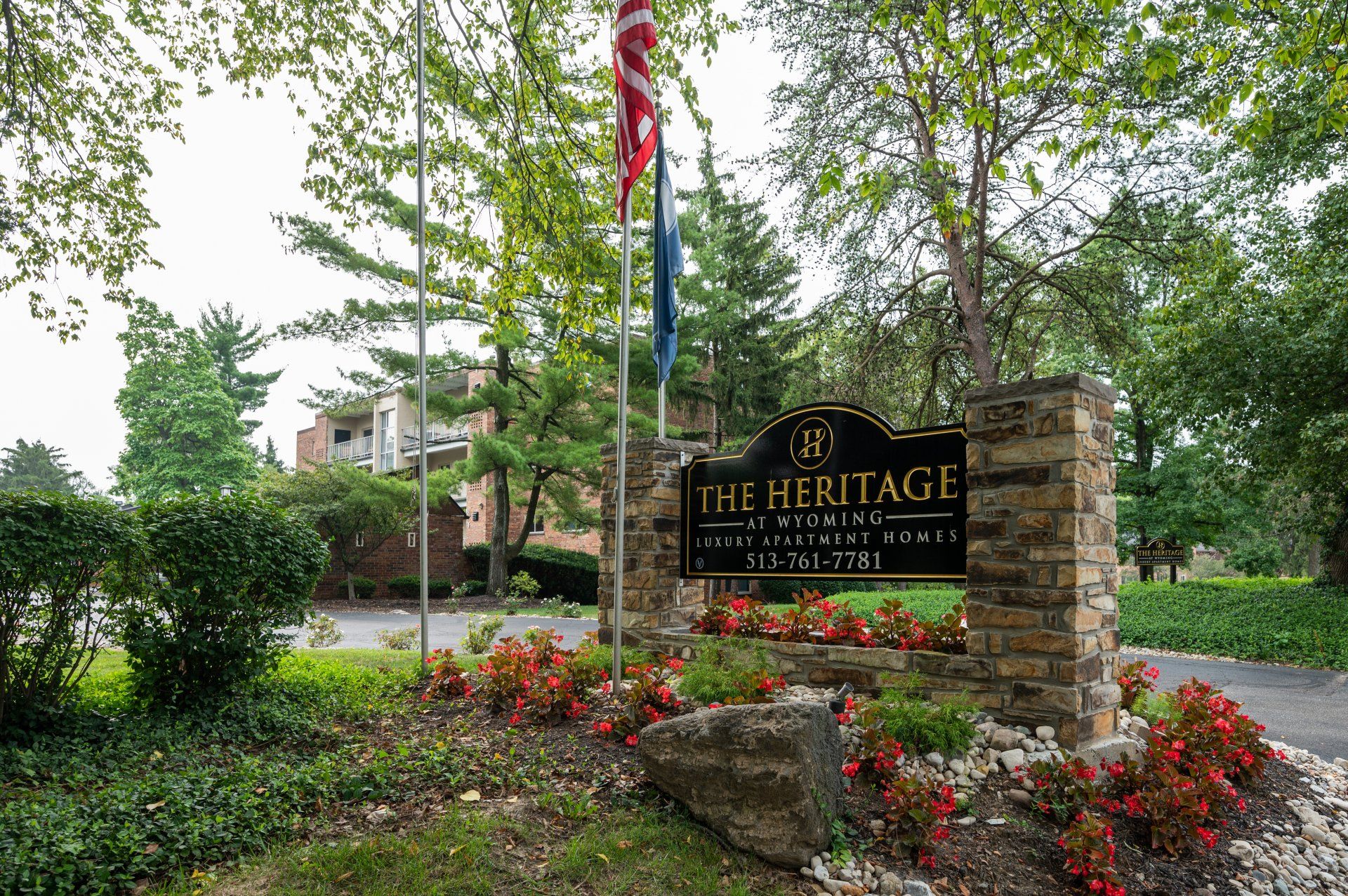 The Heritage at Wyoming community entrance sign surrounded by flowers and trees.