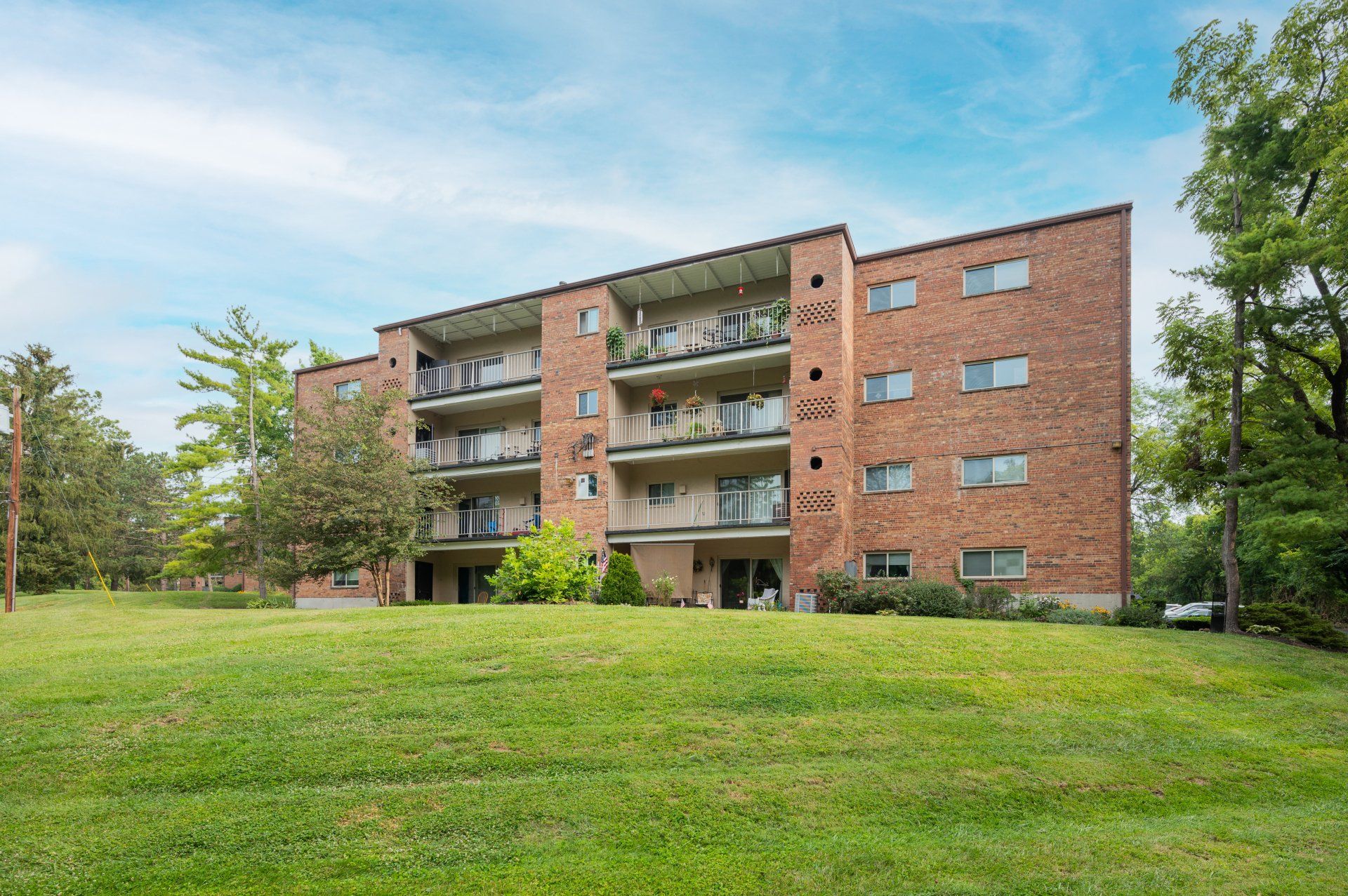 The Heritage at Wyoming brick apartment building with balconies and green lawn.