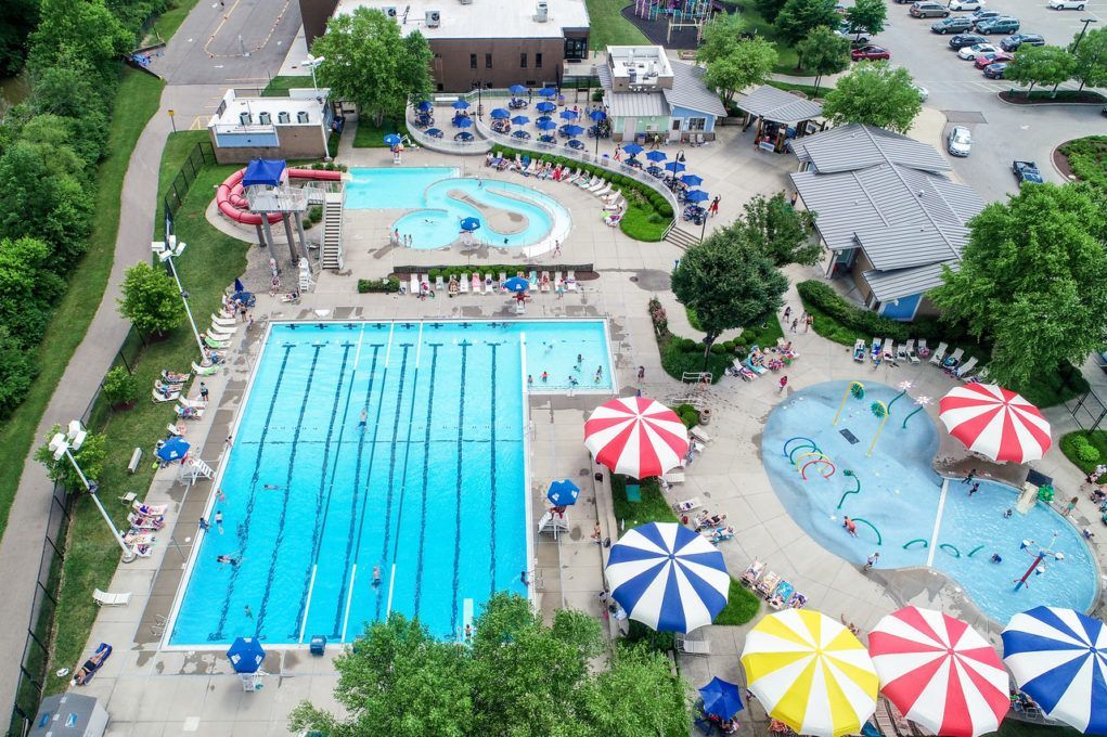 Aerial view of large outdoor pool complex with lap lanes, splash area, and lounge chairs.