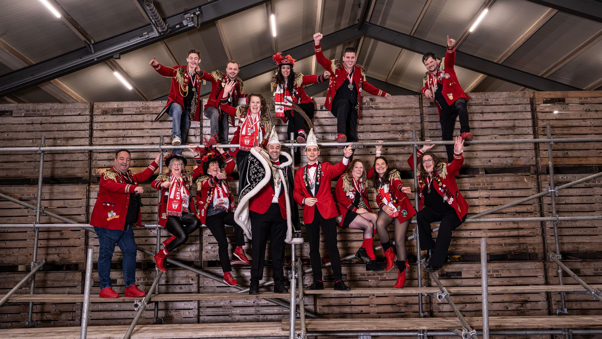 Een groep mensen poseert voor een foto voor een gebouw.