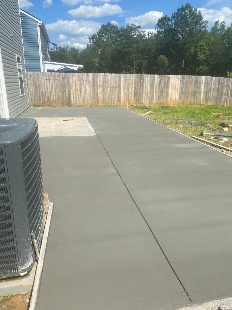 A concrete driveway is being built in front of a house.