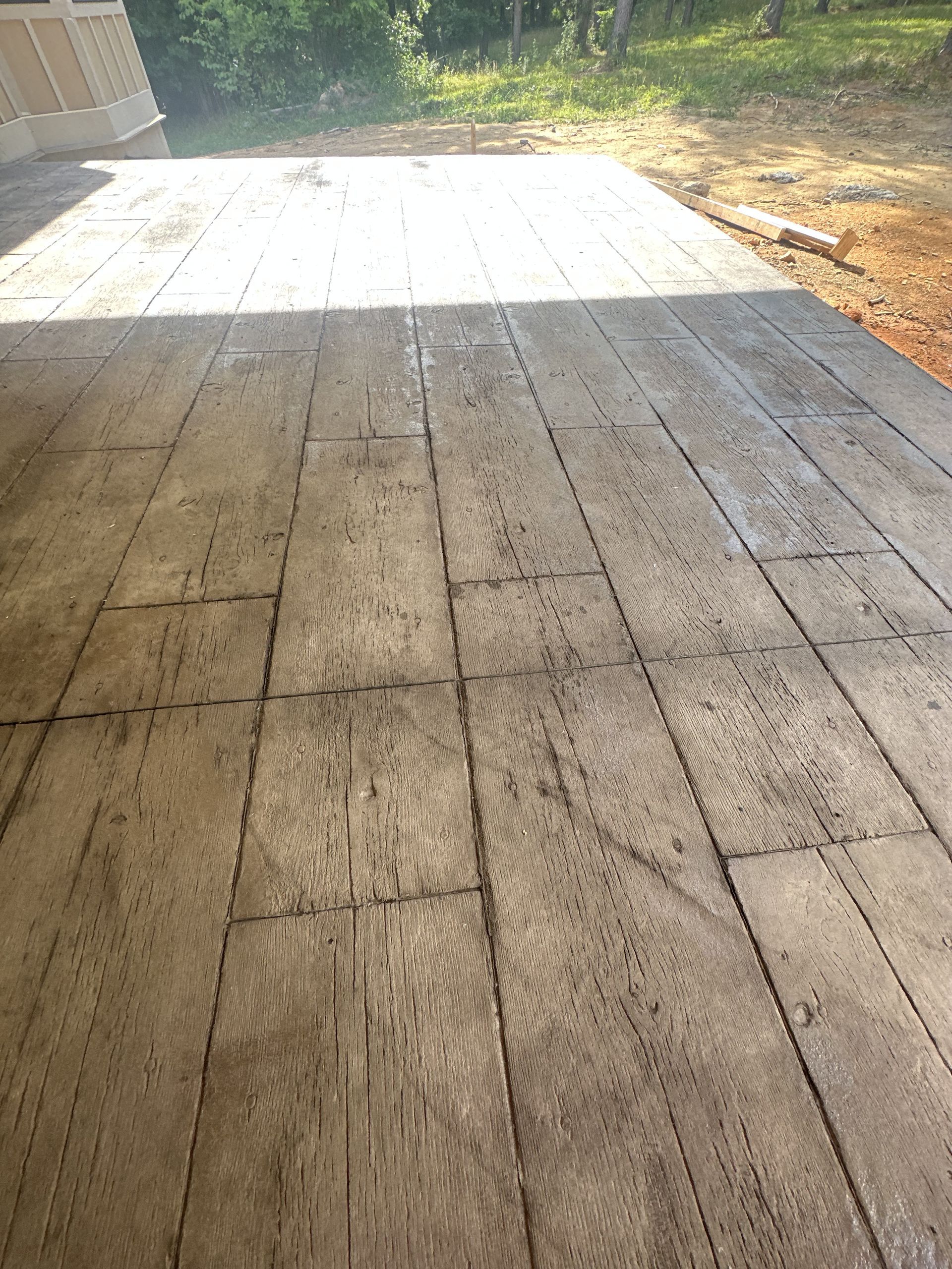 A concrete deck that looks like wood is being built.