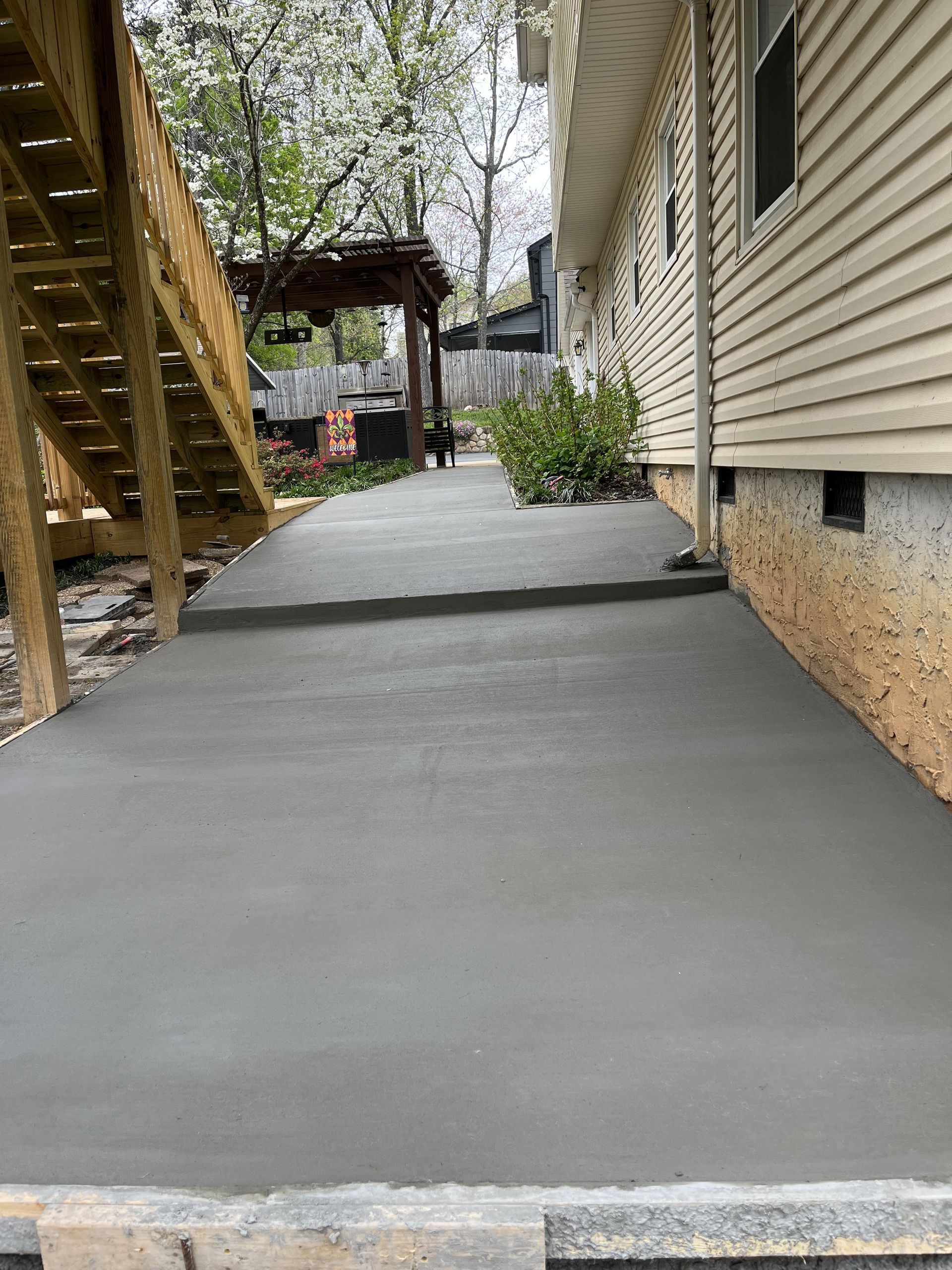 A concrete walkway is being built in front of a house.