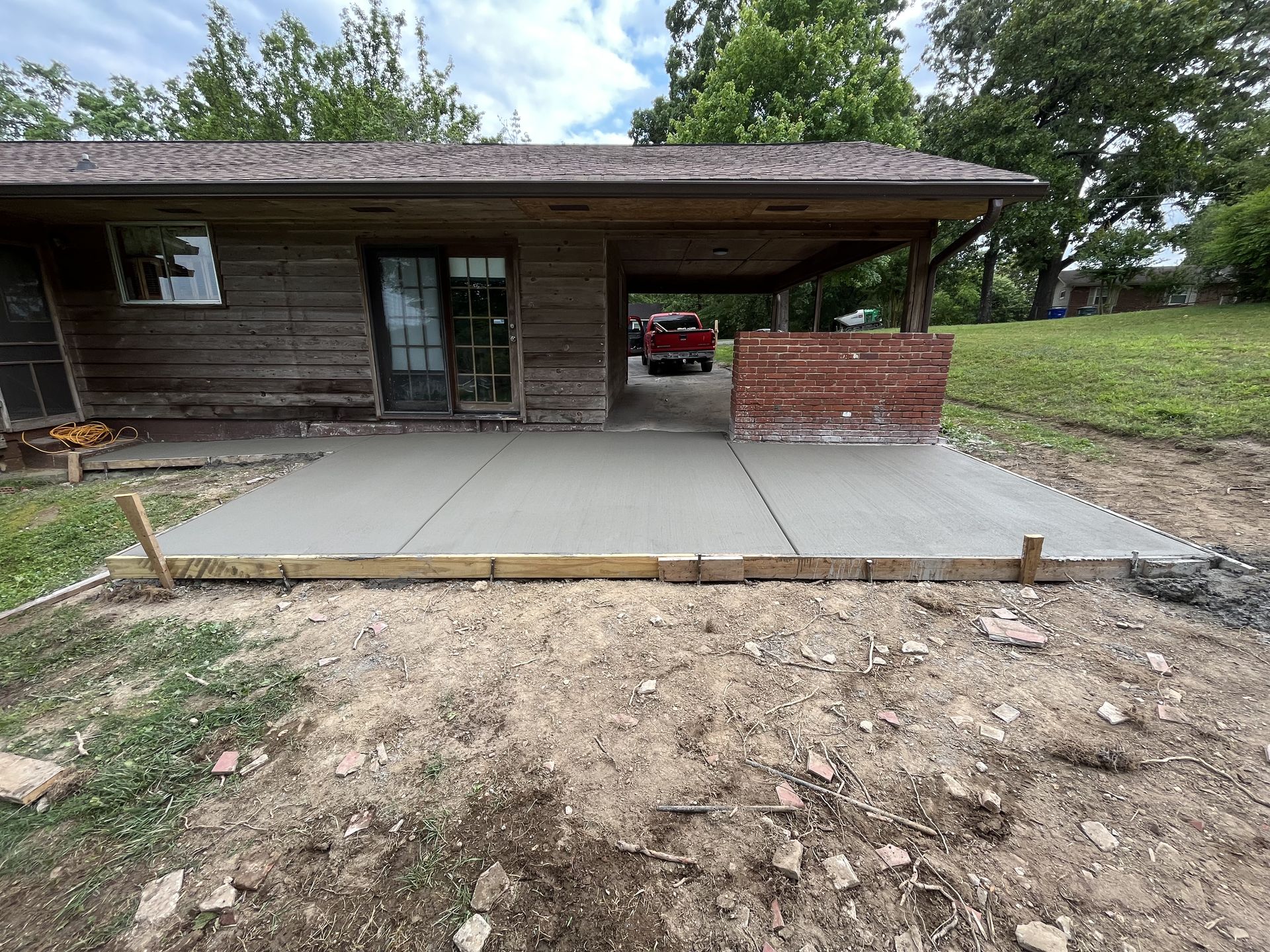 A concrete patio is being built in front of a house.