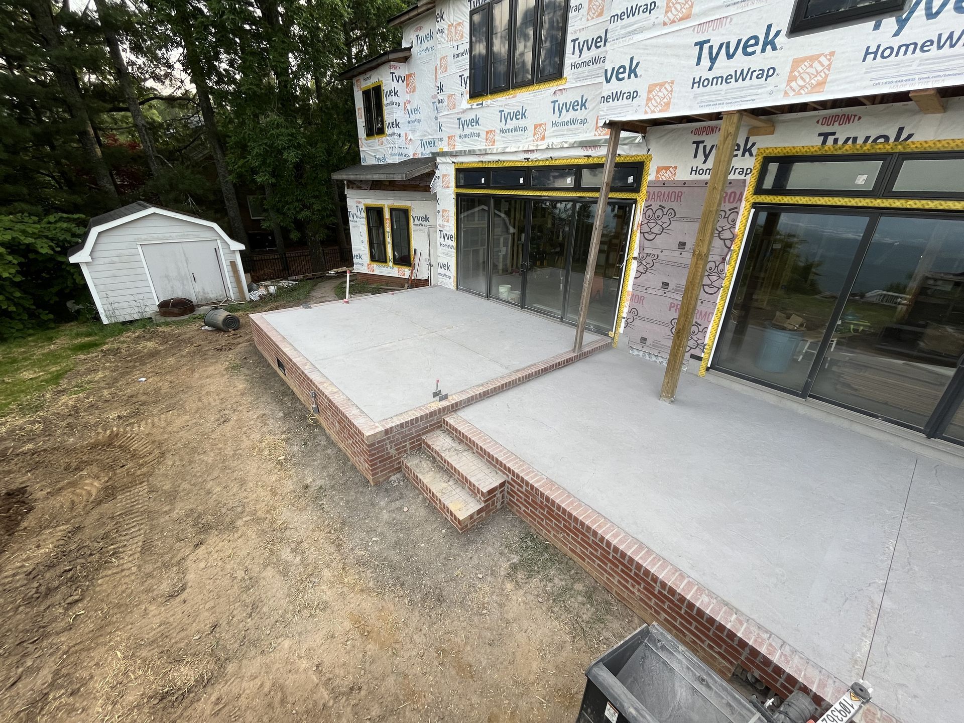 A house is being built with a large patio in front of it.