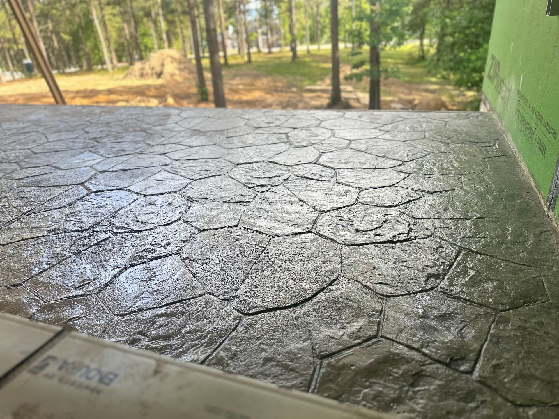 A close up of a concrete floor with trees in the background.