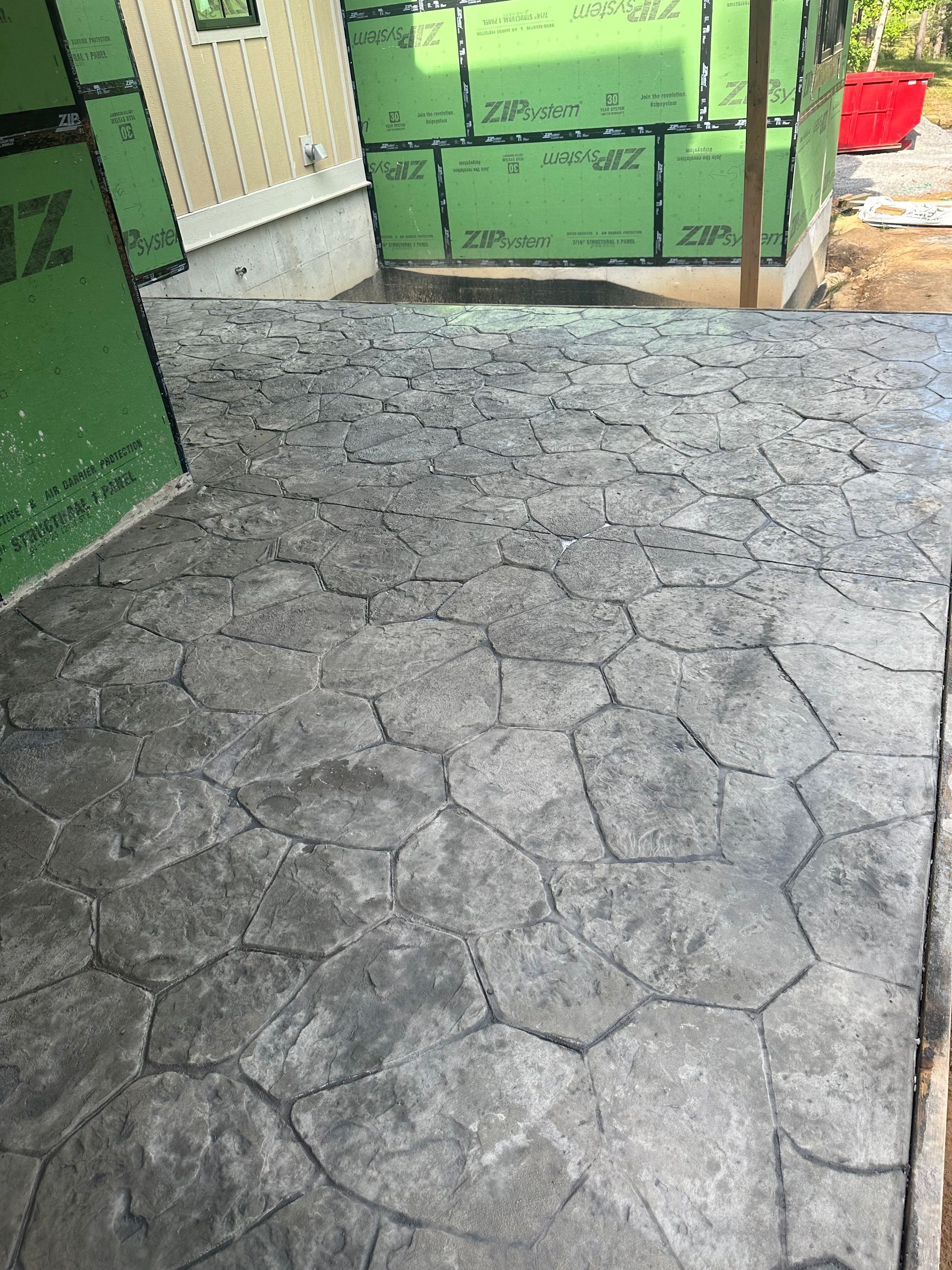 A concrete walkway is being built in front of a house.