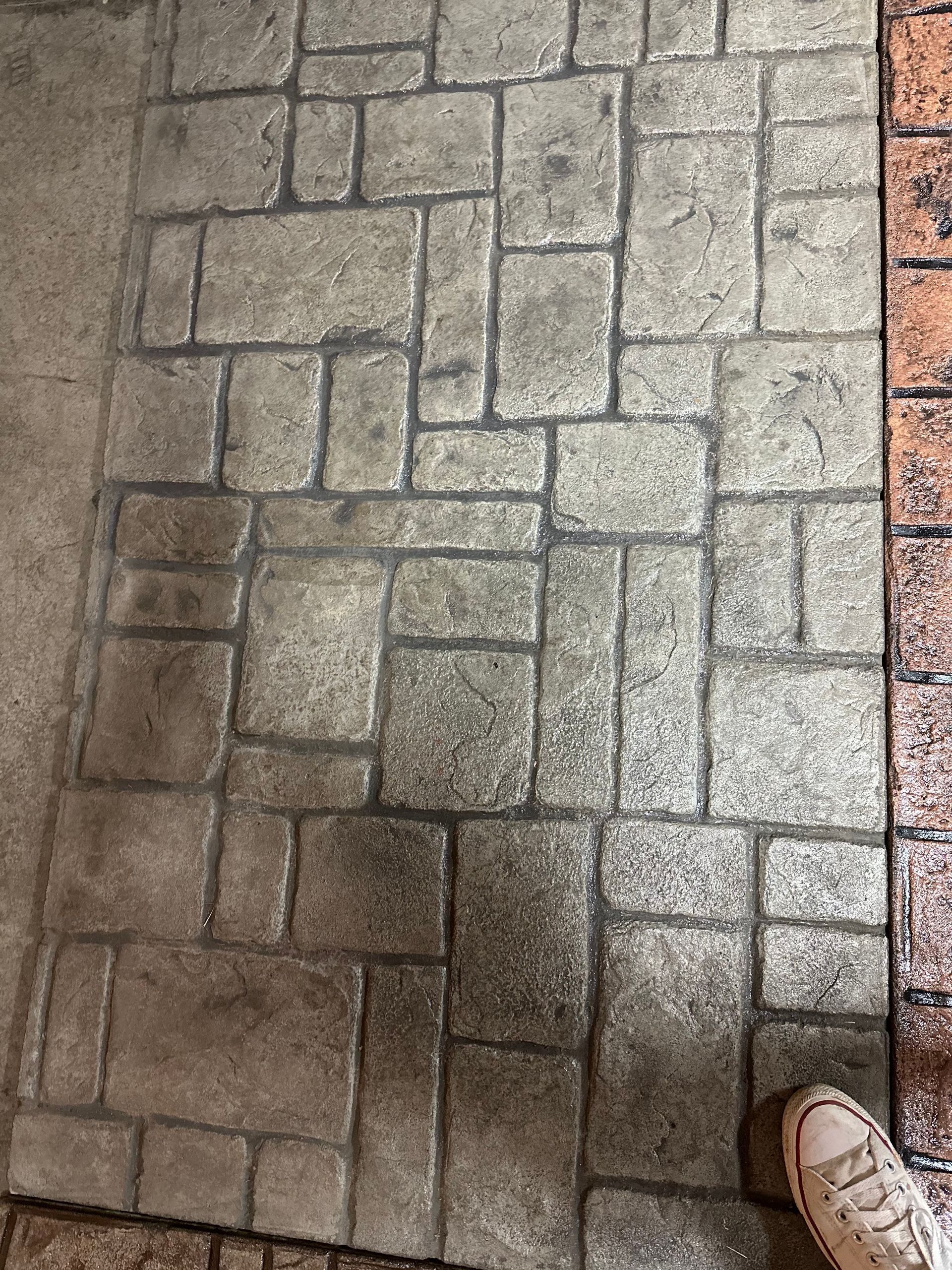 A person is standing on a brick floor.