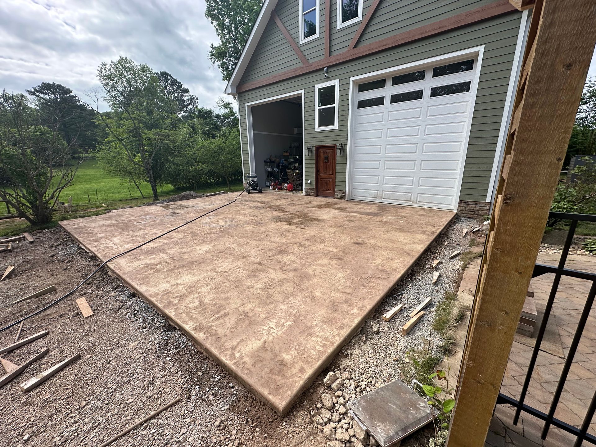 A concrete driveway is being built in front of a garage.