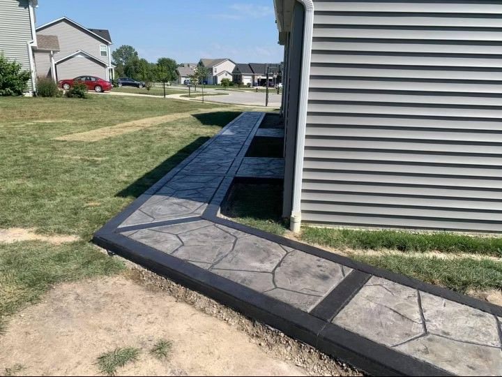 A concrete walkway leading to a house in a residential area.