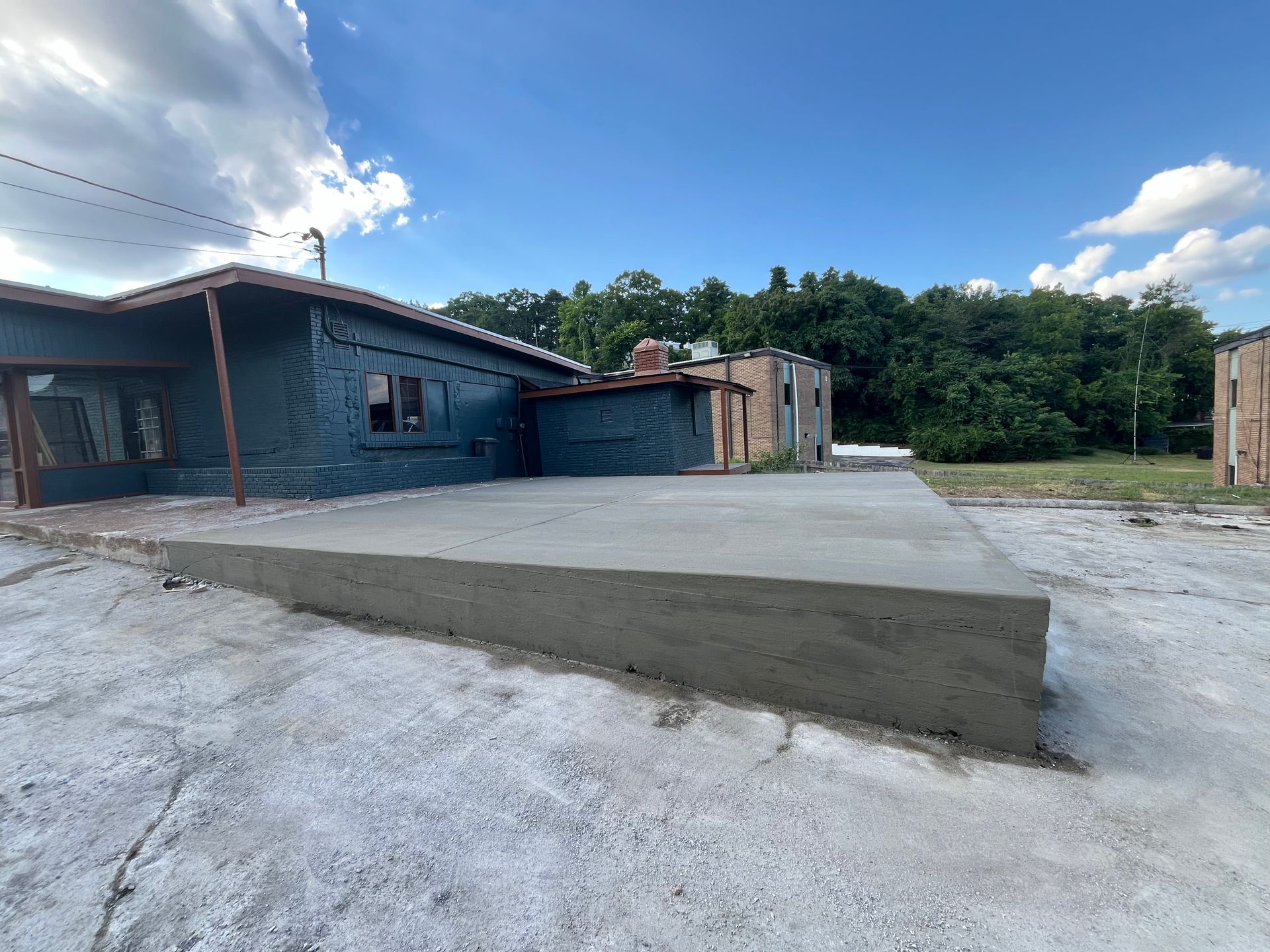 A large concrete slab is sitting in front of a building under construction.