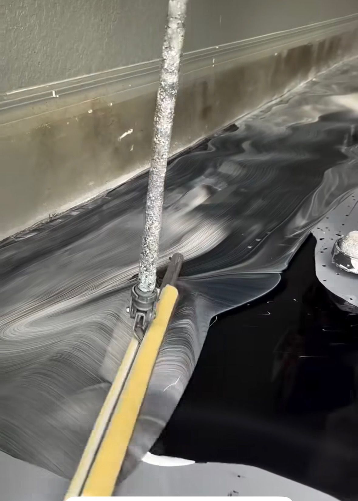 A yellow mop is being used to clean a sink.