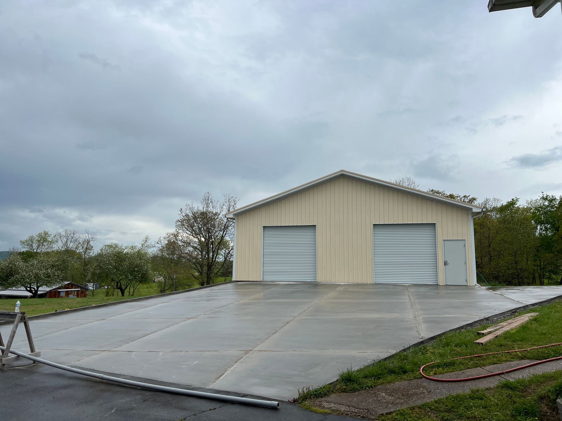 A large garage with a concrete driveway in front of it.