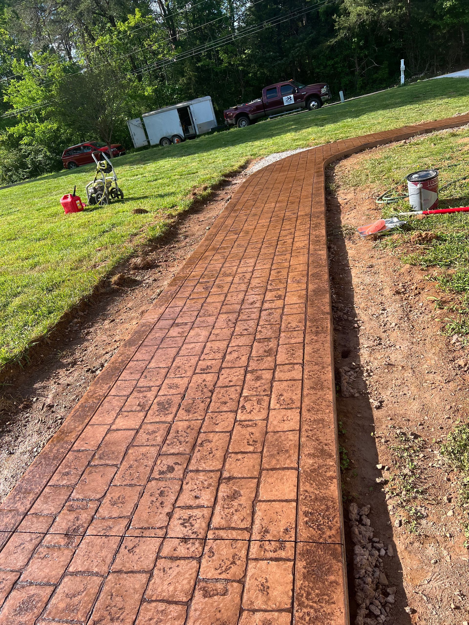 A brick walkway is being built in a yard.