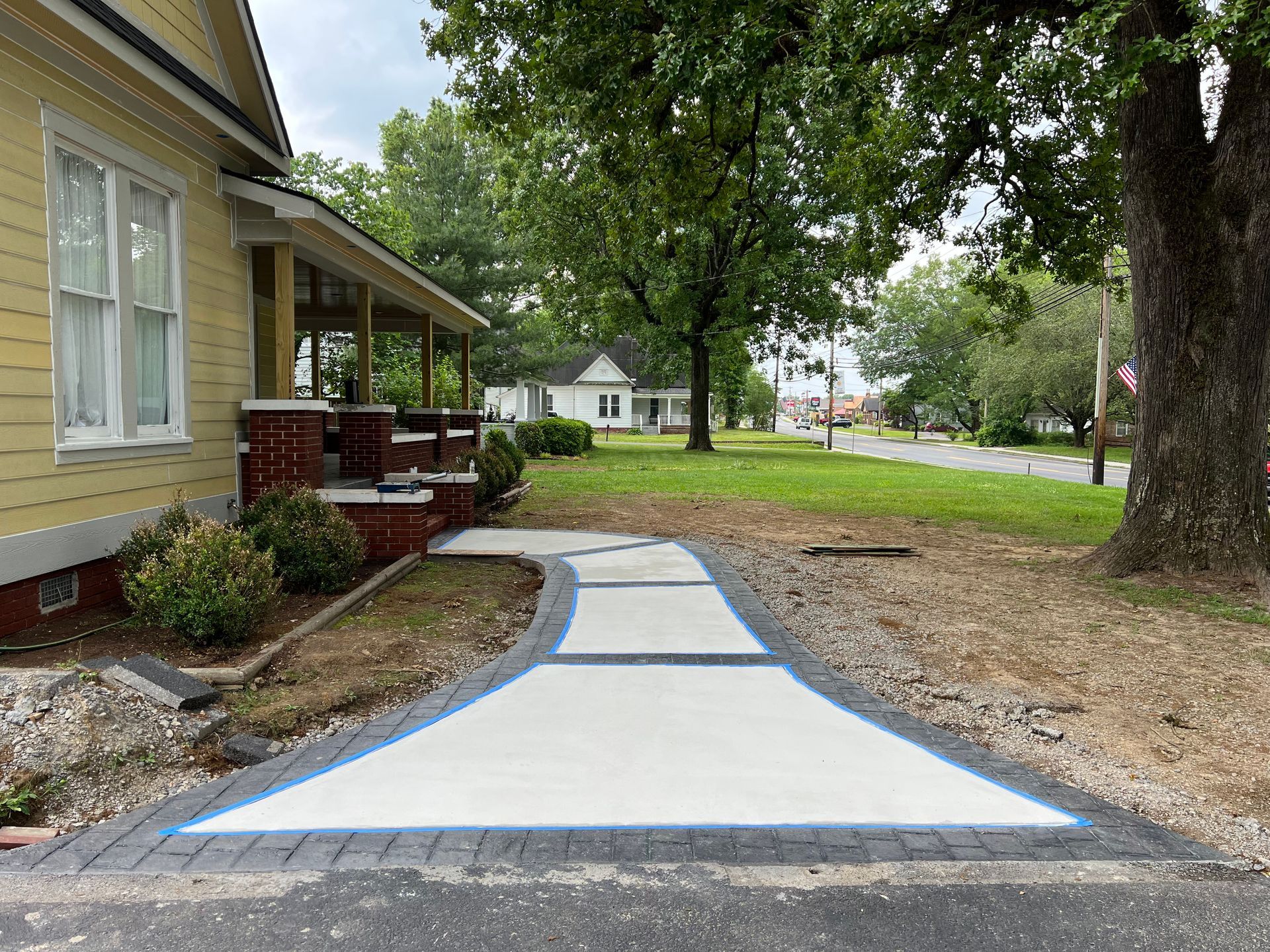 A concrete walkway is being built in front of a house.