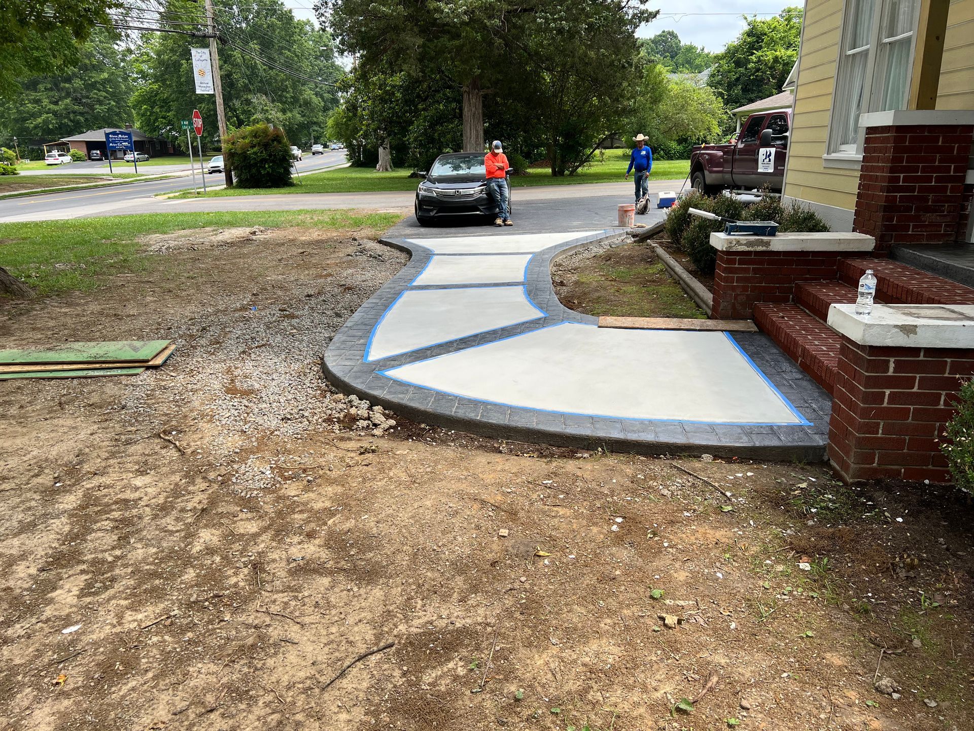 A concrete walkway is being built in front of a house.