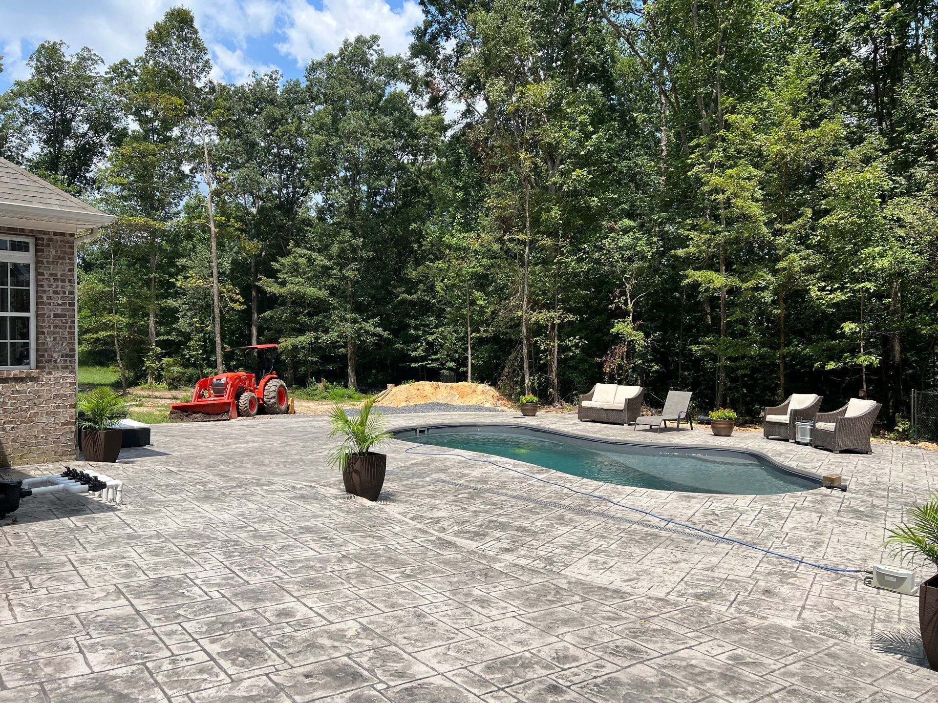 There is a large swimming pool in the backyard of a house.