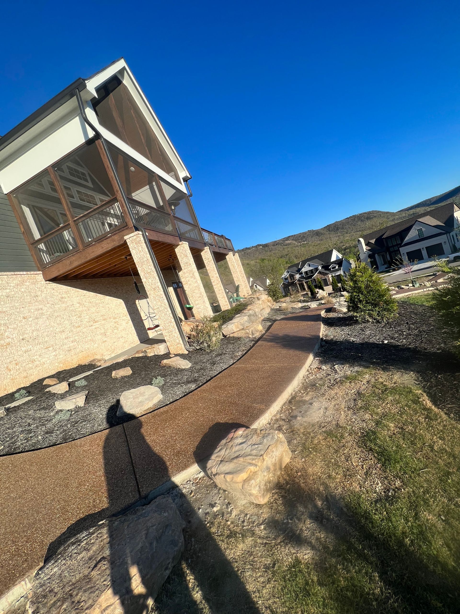 A house is sitting on top of a hill next to a path.