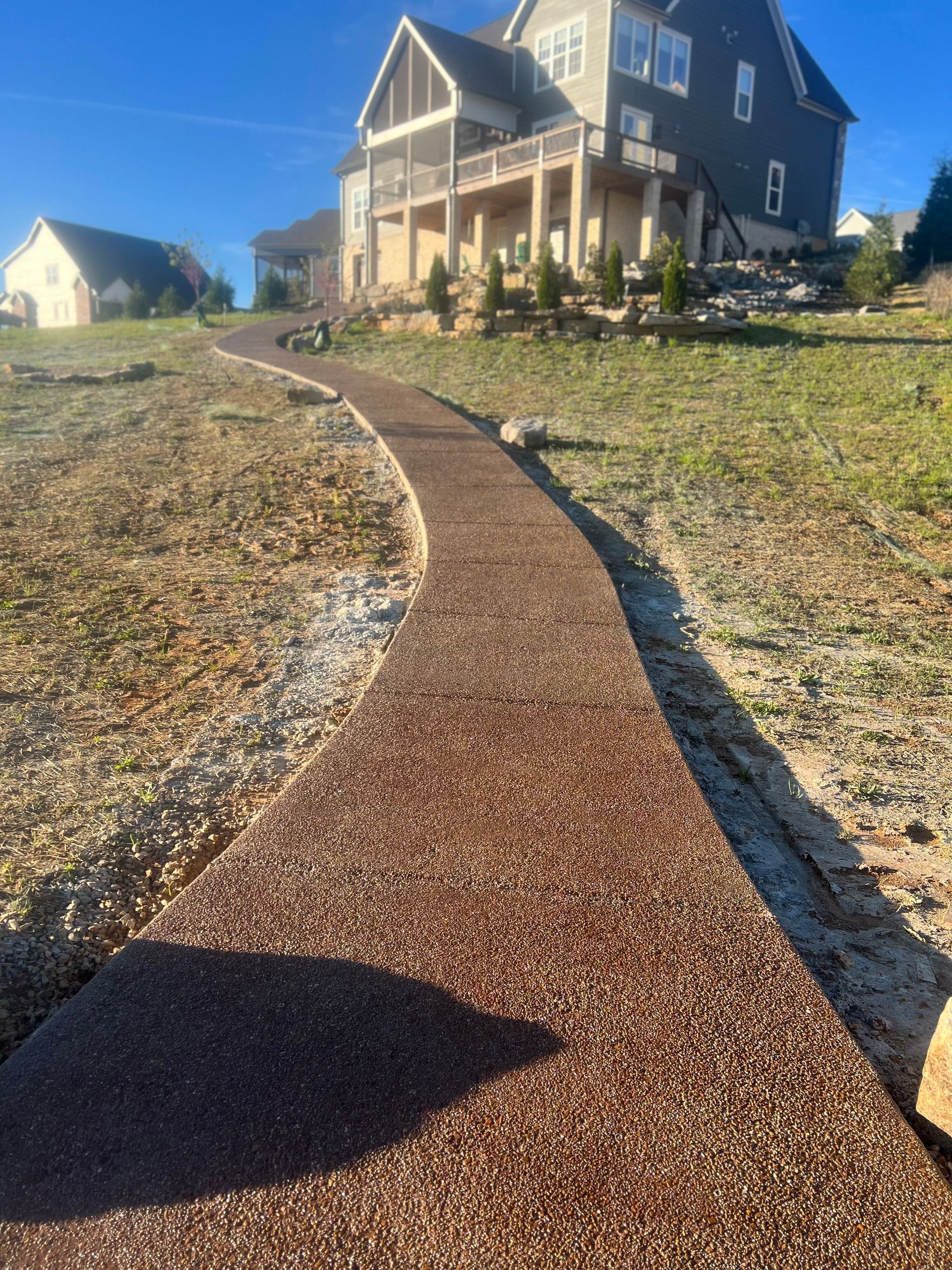 A walkway leading to a large house on a hill.