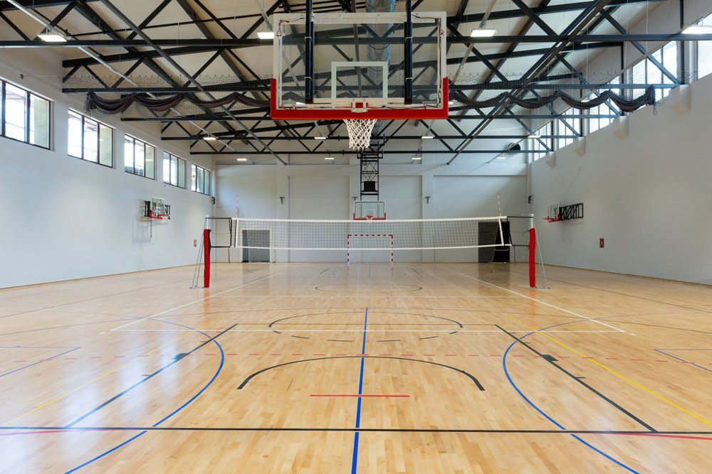 An Empty Basketball Court With A Volleyball Net And A Basketball Hoop — Remote Shopping Services In Edge Hill, QLD