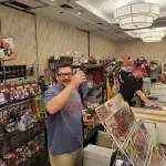 A Man Is Standing In A Room Holding A Cup Of Coffee — Aurora, CO — All C's Collectibles