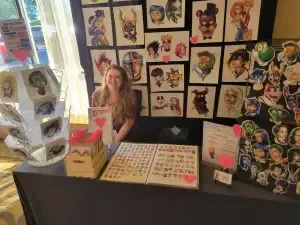 Woman Is Sitting At A Table — Aurora, CO — All C's Collectibles