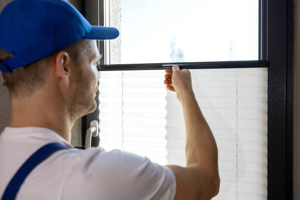 A side-angle perspective shot of closed horizontal blinds with soft sunlight filtering through.