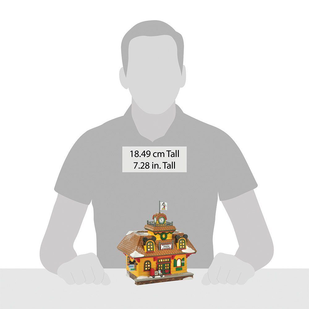 Een geel en bruin kerstdorpgebouw met een figuuroverlay en maataanduidingen.