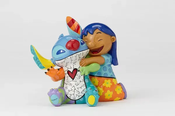 Lilo omhelst een Stitch-figuurtje; beiden zijn felgekleurd, lachen en staan ​​tegen een witte achtergrond.
