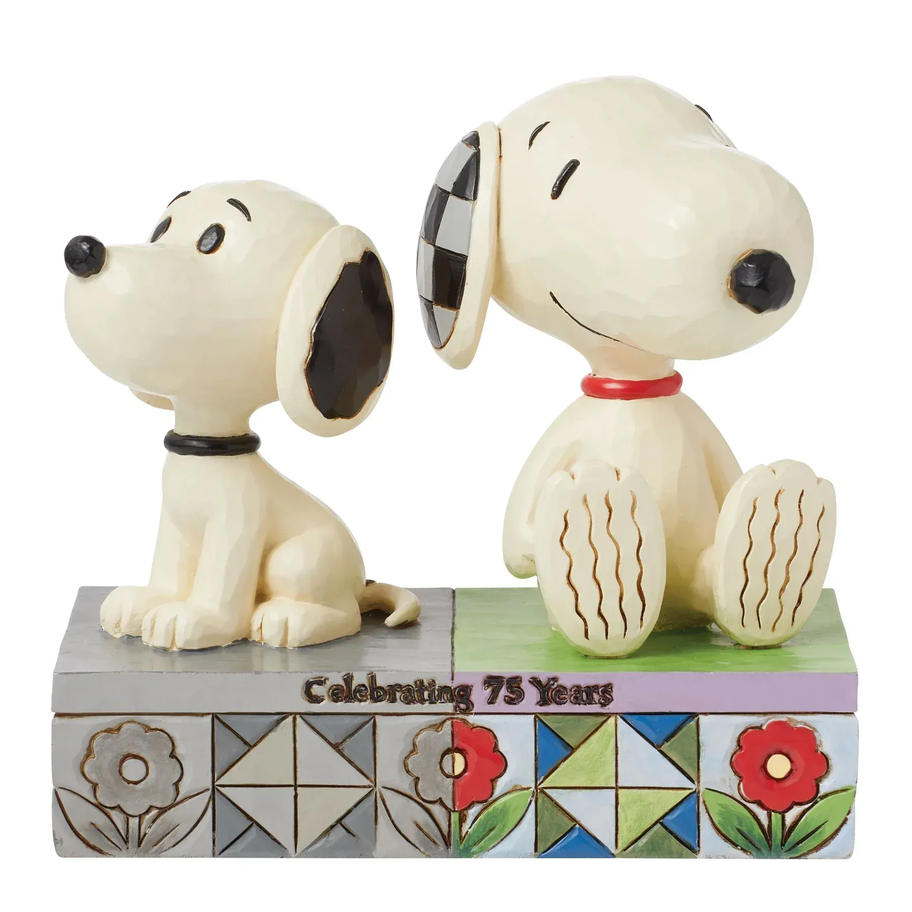 Twee snoopy-figuurtjes zitten naast elkaar op een doos.