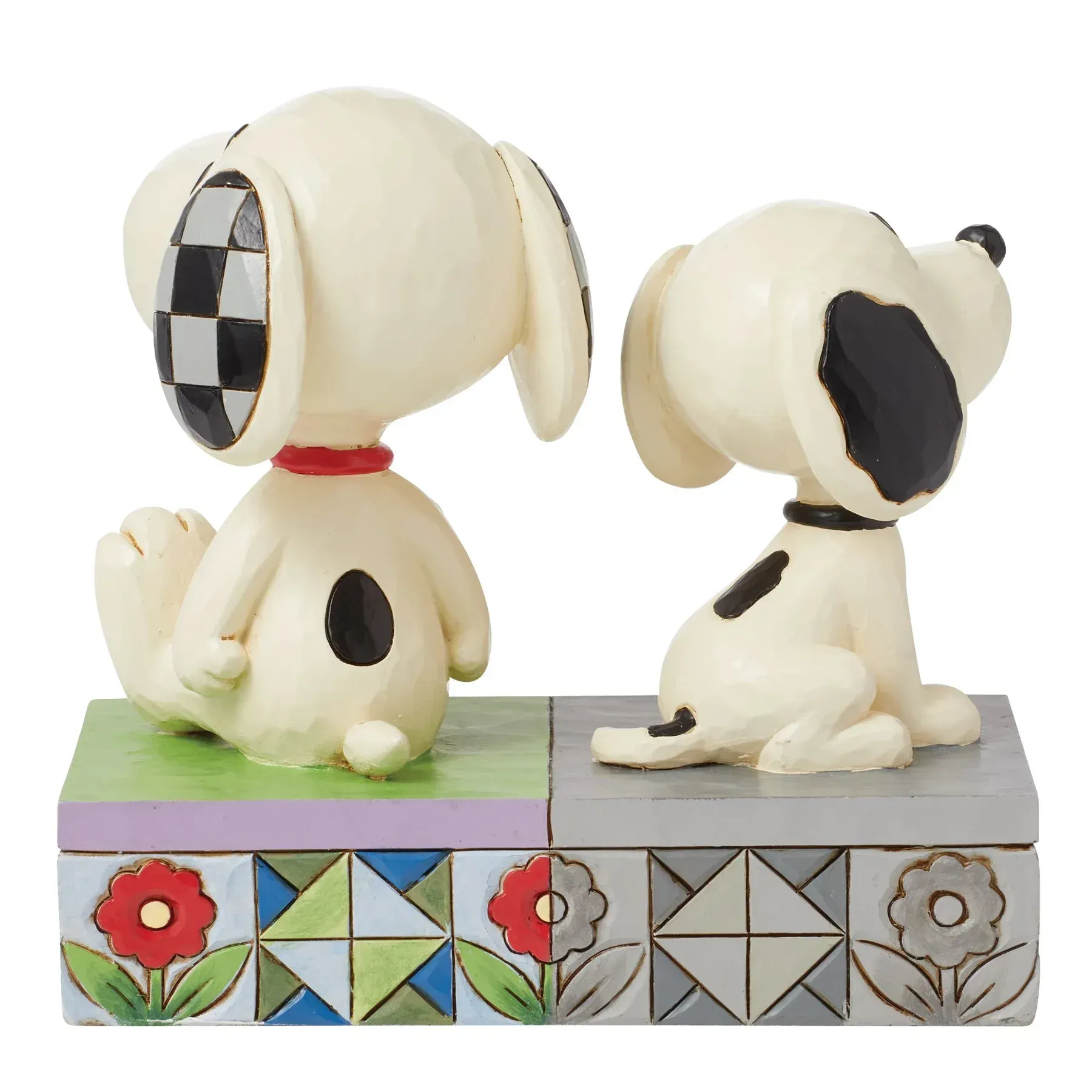 Twee snoopy-figuurtjes zitten naast elkaar op een doos.