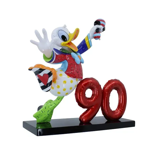 Standbeeld van Donald Duck ter ere van zijn 90e verjaardag, gekleed in een kleurrijke outfit, met een rode ballon met het cijfer 