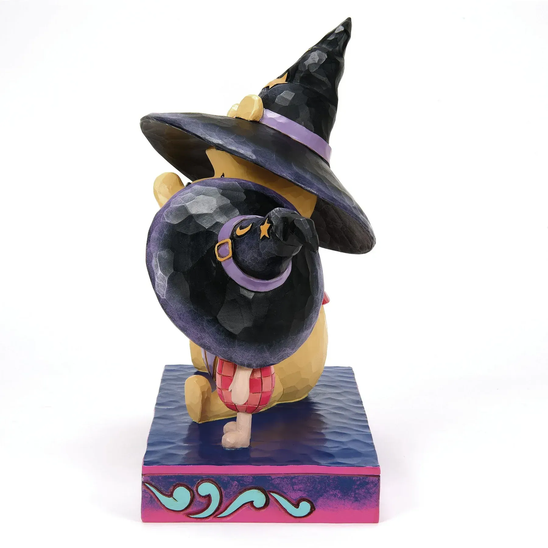 Een beeldje van Winnie de Poeh met een heksenhoed