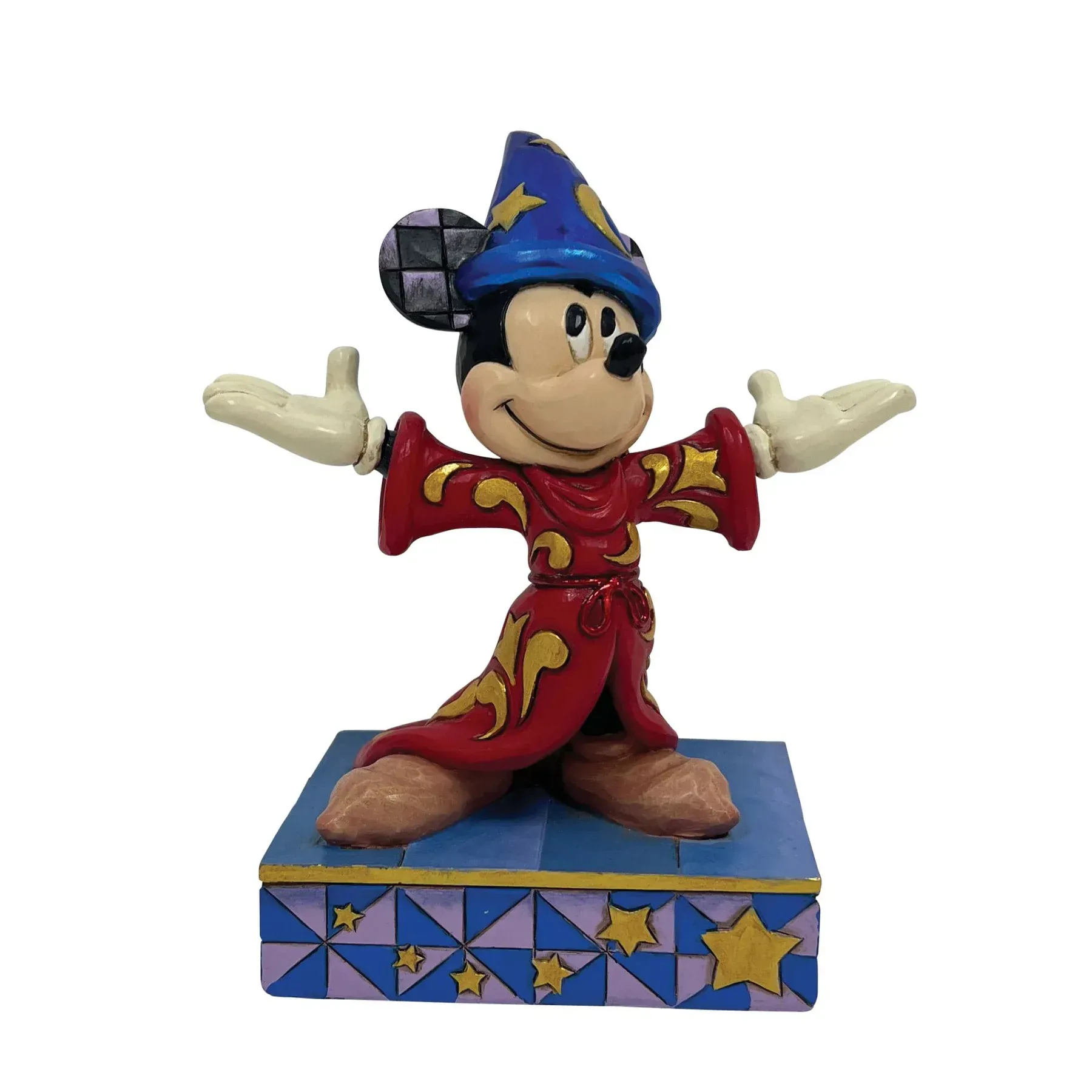 Een beeldje van Mickey Mouse, gekleed als tovenaar met zijn armen uitgestrekt.