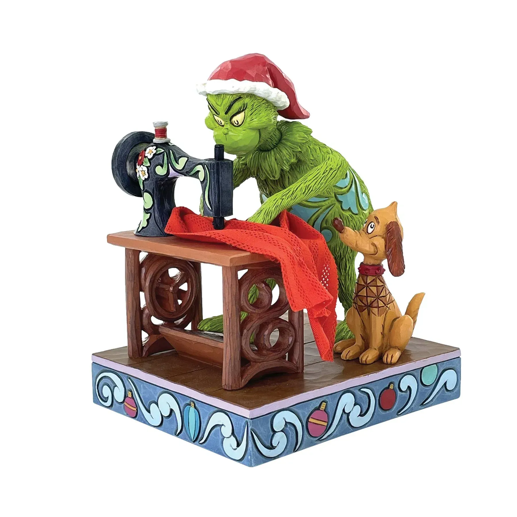 Een beeldje van de Grinch die een naaimachine gebruikt.