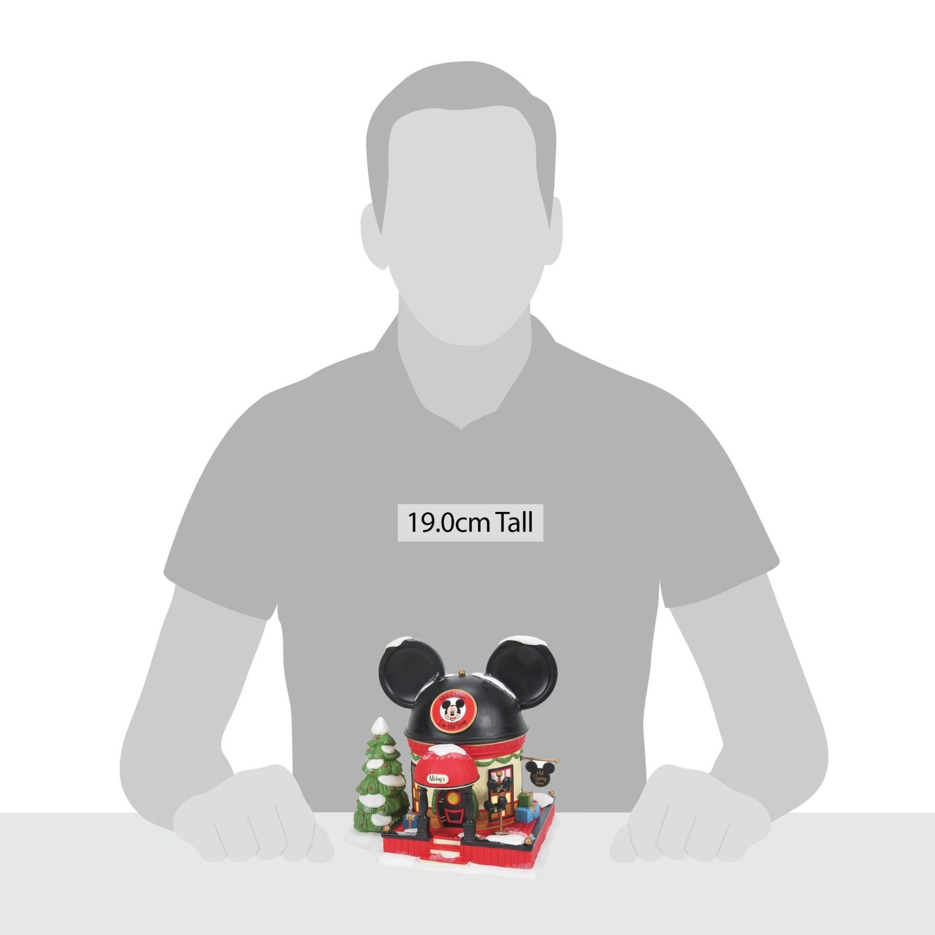 Kerstversiering met Mickey Mouse-thema: een zwart, rood en wit gebouw met een kerstboom.