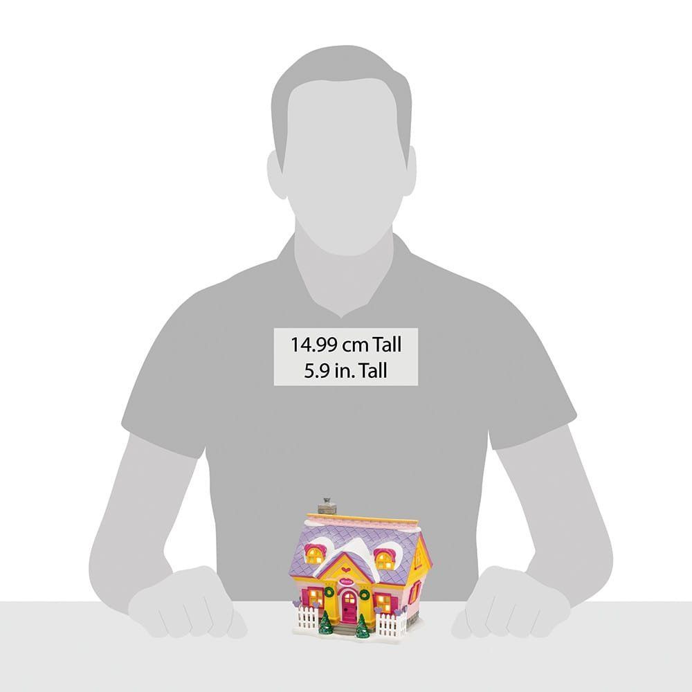 Geel en paars kersthuisje met een schaalvergelijking naar een persoon.