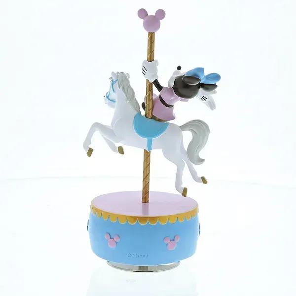 Minnie Mouse op een carrouselpaard bovenop een muziekdoos. Pastelkleuren: roze, blauw, goud.