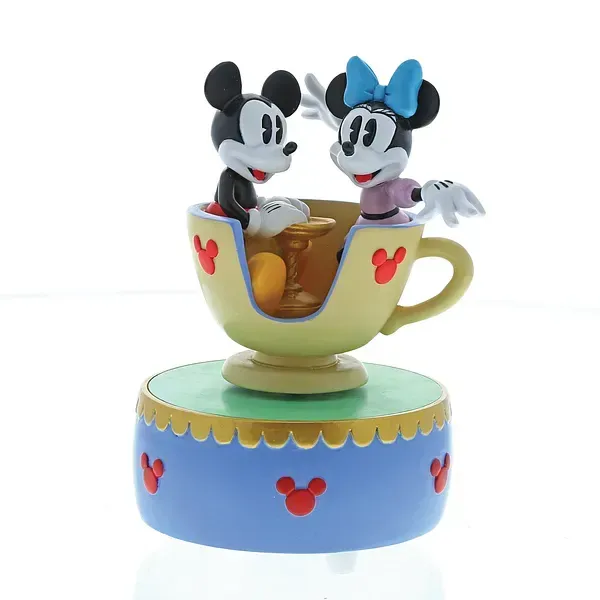 Mickey en Minnie Mouse-figuurtjes in een theekopje, op een blauwe voet versierd met Mickey Mouse-pictogrammen.