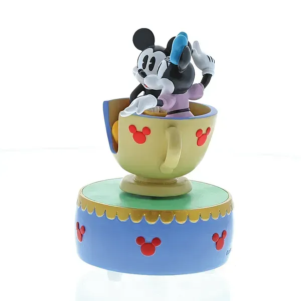 Mickey en Minnie Mouse in een muziekdoosje in de vorm van een theekopje. In de kleuren crème, geel, blauw en rood.