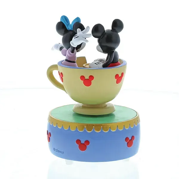 Mickey en Minnie Mouse-figuurtjes in een theekopje, bovenop een blauw, rood en geel muziekdoosje.