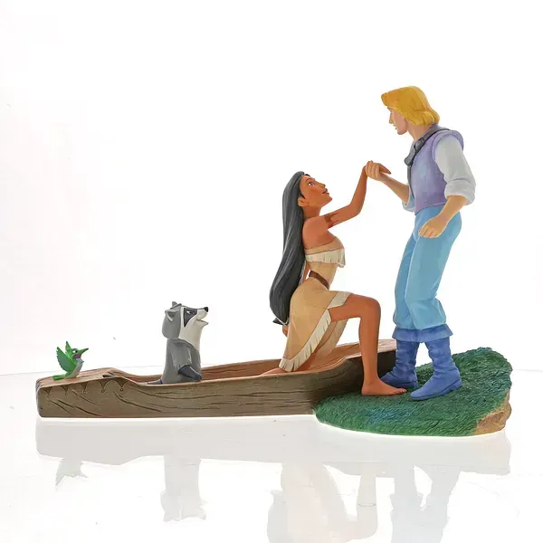 Beeldjes van Pocahontas en John Smith. Zij knielt in een kano en houdt zijn hand vast. Wasbeer Meeko kijkt toe.